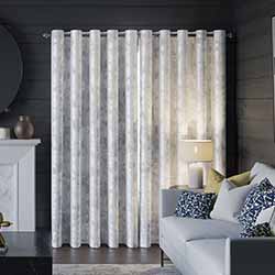 A beautiful set of white taped wooden blinds in a very bright room